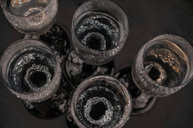 Viking Çağı yüzüğü. Alkol için bir bardağın arka planındaki mücevher yüzüğü. Koyu arkaplanda gümüş bir yüzük