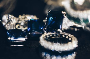 Yakından Sapphire marka mücevher. Mavi safir ve elmaslı güzel altın küpeler. Lüks kadınların mücevherleri, siyah arka planda yakın plan.