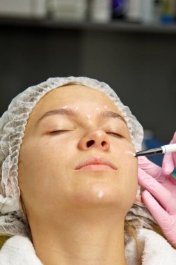 Yüzünde estetik ameliyat talimatları olan çekici bir hasta. Cerrah bir insanın yüzüne dokunuyor. Estetik kozmetoloji ve enjeksiyon kavramı