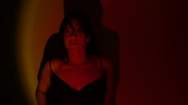 Neon ışıklı genç kız. Kız elleriyle saçına dokunuyor. Disko ışıklarındaki kadın. Yakın plan.