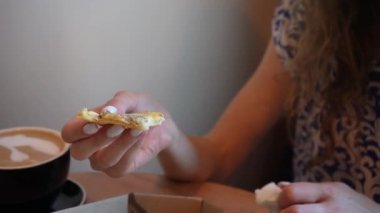 Kapalı mekanda pizza yiyen genç bir kadının yakın çekimi. Yumuşak doğal ışık, o anın huzurlu ve rahat atmosferini vurgular.