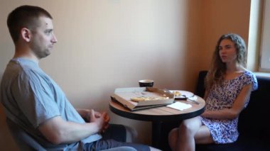 Genç bir kız ve bir adam içki ve yemekle bir masada oturuyorlar. Bir çift sevgili randevuda pizza yer ve tatlıyla kahve içerler.