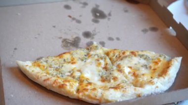 Peynirli pizza, ahşap kahverengi bir masanın üzerindeki karton kutunun üzerinde yatıyor. Baharatlı pizza.