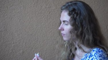 Elinde bir parça yemek tutan mutlu, güzel bir kadın. Sarı arka planda bir kız pizza yiyor, yakın plan. Kız bir kafede dinleniyor.