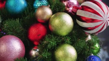 Arka plan olarak çok renkli Noel oyuncakları. Noel ağacı dallı plastik renkli toplar.