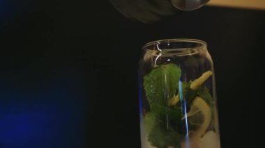 Mavi arka planda bardakta taze yaz kokteyli. Turunçgiller ve buzla dolu bir bardakta pembe su