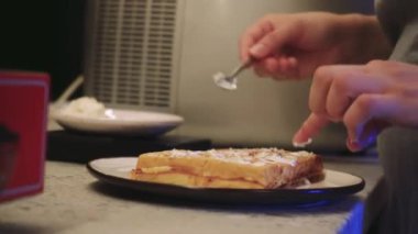 Genç bir kadının marifetli bir şekilde waffle 'ları krem peynirle dolduruşunu izleyin, adım adım. Bu video lezzetli ve sağlıklı malzemeler arasındaki dengeyi vurguluyor.