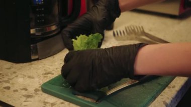 Süreç, ev yemeği ve sağlıklı malzemelerin kombinasyonunu gösteriyor. Genç bir kadın mutfakta lezzetli waffle hazırlıyor, üzerine taze marul ve domates ekliyor.