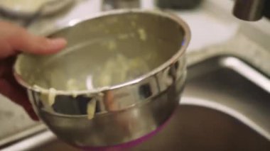 Mutfakta yemek pişirme işlemi. Bir kadın yemek pişirdikten sonra aletleri temizler ve yıkar.