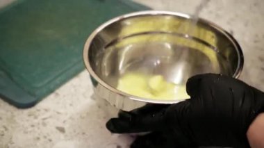 Lezzetli waffle yapma süreci genç bir kadın hamuru hazırlayıp elektrikli waffle makinesine döktüğünde gerçekleşir. Detaylara dikkat ve taze malzemeler anahtar elementlerdir.