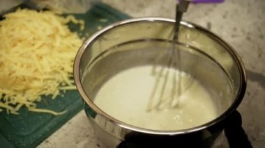 Video besleyici yemekler yaratmaya yönelik bakım ve ilgiyi vurguluyor. Waffle için hamur yoğuran ve lezzetli bir kahvaltı hazırlayan genç bir kadının yakın plan görüntüsü.