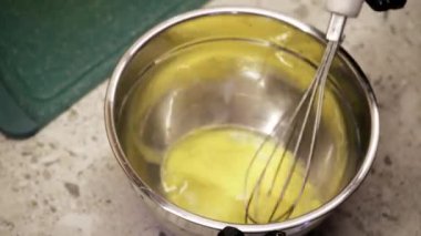 Genç bir kadın waffle için sıvı hamur yoğuruyor. Kız lezzetli bir tat için ustaca pastırma ve peynir ekliyor, her seferinde aşçılık yeteneklerini sergiliyor.