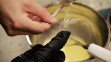 Genç bir kadın waffle için sıvı hamur yoğuruyor. Kız lezzetli bir tat için ustaca pastırma ve peynir ekliyor, her seferinde aşçılık yeteneklerini sergiliyor.