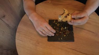 Bu sahnede bir kruvasan var. Elinde bir parça hamur işi tutan genç bir adam var. Video, taze pişmiş hamurun cazibesini taşıyor.