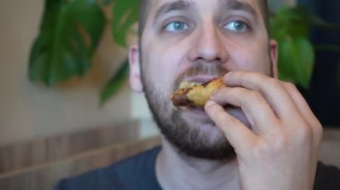 Bir adam sıcak, altın bir kruvasanı parçalayarak kokunun ve lezzetinin tadını çıkarıyor. Video, bir ısırık aldığı anı yakalar ve hoşgörülü davranışın tadını çıkarır.