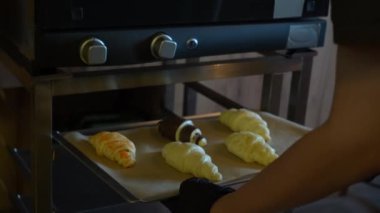 Fırında pişmemiş kruvasanların yakında altın rengi kahverengi ve çıtır çıtır olacağı görülüyor. Pişirmede nefis bir beklenti anı