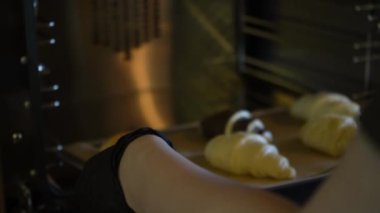 Fırında pişmemiş kruvasanların yakında altın rengi kahverengi ve çıtır çıtır olacağı görülüyor. Pişirmede nefis bir beklenti anı