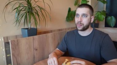 Bir adam sıcak, altın bir kruvasanı parçalayarak kokunun ve lezzetinin tadını çıkarıyor. Video, bir ısırık aldığı anı yakalar ve hoşgörülü davranışın tadını çıkarır.