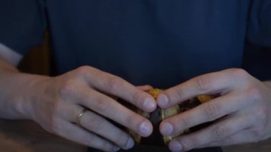 Yüzüklü bir el, çikolatalı kruvasanı kırar ve hamur işlerinin zengin aromasının tadını çıkarır. Taze pişmiş ikramın zevkini yakaladığımız an