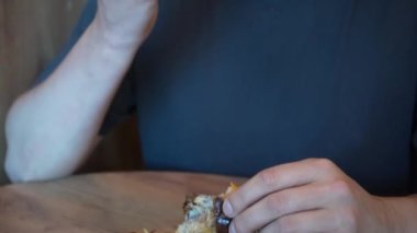 Çikolatayla kaplı taze kruvasanın tadını çıkaran genç bir adam bu pastanın tazeliğini ve kokusunu aktarıyor.