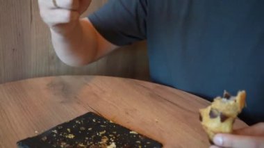 Bir adam sıcak, altın bir kruvasanı parçalayarak kokunun ve lezzetinin tadını çıkarıyor. Video, bir ısırık aldığı anı yakalar ve hoşgörülü davranışın tadını çıkarır.