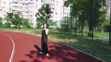 Spor sahası olan bir apartmanın önünde bir kız düşünceye dalıyor. Kentsel yaşam ve tefekkür temaları için ideal