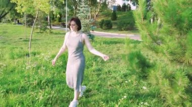 Gün batımında sakin bir nehrin kenarında yürüyen bir kadın huzurlu ve huzurlu bir atmosfer yaratıyor. Rahatlama, doğa ve açık hava yaşam tarzı görüntüleri için harika.
