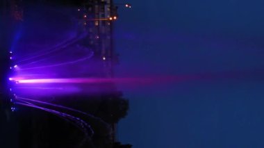 Renkli su fıskiyeleri ile canlı bir fıskiye gösterisi. Karanlık bir arkaplanda dans ederek büyüleyici bir gece gösterisi yaratıyor.