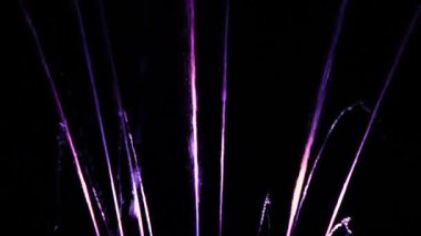 Karanlık arka plan. Büyük renkli dekoratif dans jeti geceleri hafif fıskiye gösterisine öncülük etti. Güzel bir lazer ve fıskiye gösterisi. Renkli su çeşmeleri