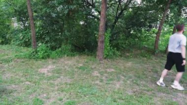 Koyu renk tişörtlü bir adam yemyeşil, fazla gelişmiş bir bölgeyi keşfediyor. Yeşillikte yavaşça yürüyor, doğada sakin bir sahne yaratıyor. Macera, rahatlama ve yalnızlık temaları için mükemmel.