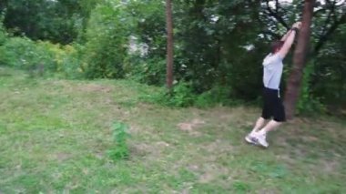 Doğada yapayalnız bir yürüyüş, yeşilliklerle çevrili genç adam, açık hava ve rahatlama temalı içerik için mükemmel.