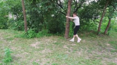 Doğada yapayalnız bir yürüyüş, yeşilliklerle çevrili genç adam, açık hava ve rahatlama temalı içerik için mükemmel.