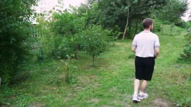 Doğada yapayalnız bir yürüyüş, yeşilliklerle çevrili genç adam, açık hava ve rahatlama temalı içerik için mükemmel.