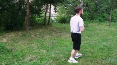 Çimenli bir yolda yürüyen bir adam doğal bir manzaranın huzurunun tadını çıkarır. Rahatlama ve açık hava içeriği için mükemmel.