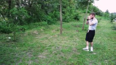 Yeşil yemyeşil bir parkta tek başına yürüyen bir adam, doğa tarafından çevrelenmiş sessiz bir anın tadını çıkarıyor. Rahatlama temaları için harika