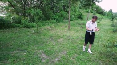 Yeşil yemyeşil bir parkta tek başına yürüyen bir adam, doğa tarafından çevrelenmiş sessiz bir anın tadını çıkarıyor. Rahatlama temaları için harika