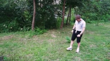 Yeşil yemyeşil bir parkta tek başına yürüyen bir adam, doğa tarafından çevrelenmiş sessiz bir anın tadını çıkarıyor. Rahatlama temaları için harika