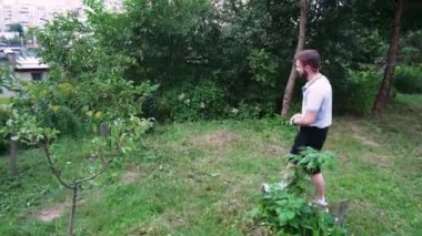 Yeşil yemyeşil bir parkta tek başına yürüyen bir adam, doğa tarafından çevrelenmiş sessiz bir anın tadını çıkarıyor. Rahatlama temaları için harika