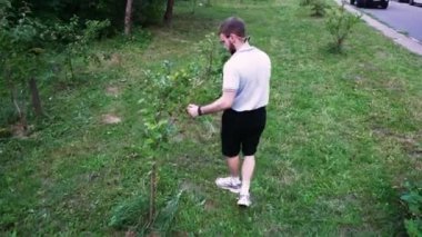Çimenli bir yolda yürüyen, doğal bir ortama dalmış bir adamın arka görüntüsü. Açık hava ve yaşam tarzı içeriği için ideal