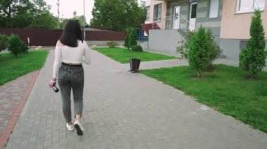 Yaşam tarzı ya da gayrimenkul imajı için ideal. Gündelik giysiler içinde şık bir kadın yerleşim bölgesinde dolaşır, kendine güven ve rahatlık saçar.