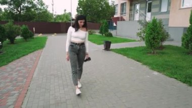 Gündelik giysiler içinde şık bir kadın yerleşim yerlerinde rahatça dolaşır. Yaşam tarzı ya da gayrimenkul görselleri için ideal