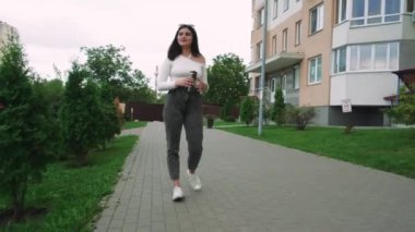 Gündelik giysiler içinde şık bir kadın yerleşim yerlerinde rahatça dolaşır. Yaşam tarzı ya da gayrimenkul görselleri için ideal