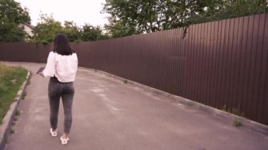 Şehir merkezinin sakinliğinin tadını çıkarırken yürüyen ve okuyan bir kadının büyüleyici bir sahnesi. Günlük yaşam tarzı ve rahatlık için harika.