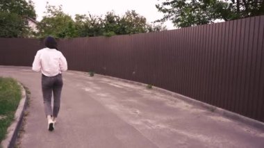 Şehir merkezinin sakinliğinin tadını çıkarırken yürüyen ve okuyan bir kadının büyüleyici bir sahnesi. Günlük yaşam tarzı ve rahatlık için harika.