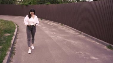 Şehir merkezinin sakinliğinin tadını çıkarırken yürüyen ve okuyan bir kadının büyüleyici bir sahnesi. Günlük yaşam tarzı ve rahatlık için harika.