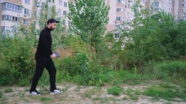 Bir adam çimenli bir yolda yürüyor, huzurlu bir ortamda doğayı keşfediyor, akıllı telefonunu elinde tutuyor. Açık hava aktiviteleri, eğlence ya da açık hava macera videoları için uygundur