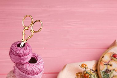 Beautiful embroidery hoop with floral design on pastel fabric, accompanied by colorful yarn spools. Perfect for showcasing needlework or DIY crafts clipart