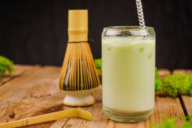 Farkındalığı ve geleneği simgeleyen, bir kibrit kutusunda dinlenen bambu kibritinin yakın plan çekimi. Bir bardak buzlu kibritli latte.