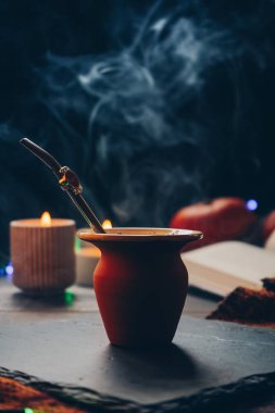 Bir erkeğin elindeki sütlü içeceğin konsantre görüntüsü. Matcha ayinlerini ve çay yapmak için el aletlerini göstermek için birebirdir. Genç bir adam sütlü bir içeceği olan bir kamışla bir bardak tutuyor.