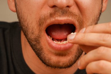 Ana odak noktası, sakallı bir adamın açık ağzının yakınında tutulan patlamış mısır. Filmden önce atıştırmalıkların tadını çıkaran bir adamın ağzına yakın çekim.